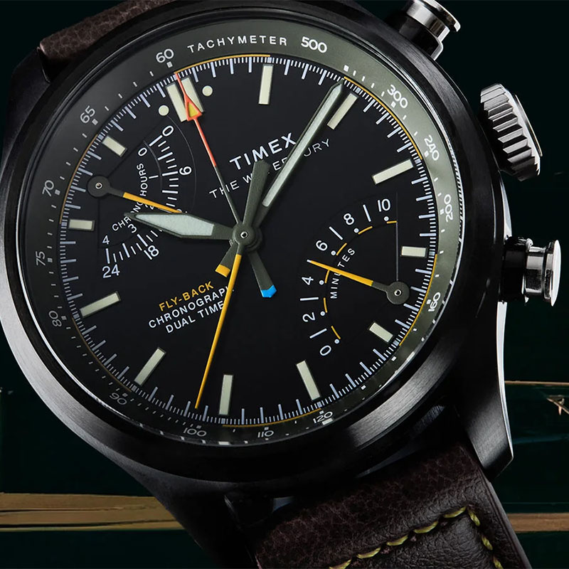 Timex Waterbury Ace Fly Back Chronograph TW2Y70100 - zbliżenie czarnej tarczy z totalizatorami, skalą tachymetryczną, wskazówką drugiej strefy czasowej i lumą