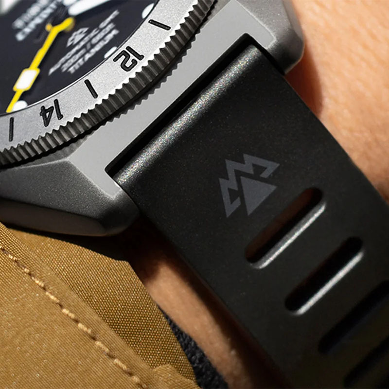 Timex Expedition Pioneer Titanium Automatic GMT TW2W53000 - zbliżenie gumowego paska z logo Expedition North przy tytanowej kopercie